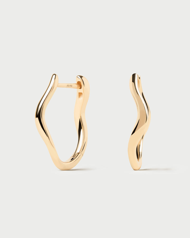 Modern oval hoops in 18K yellow gold featuring fluid lines