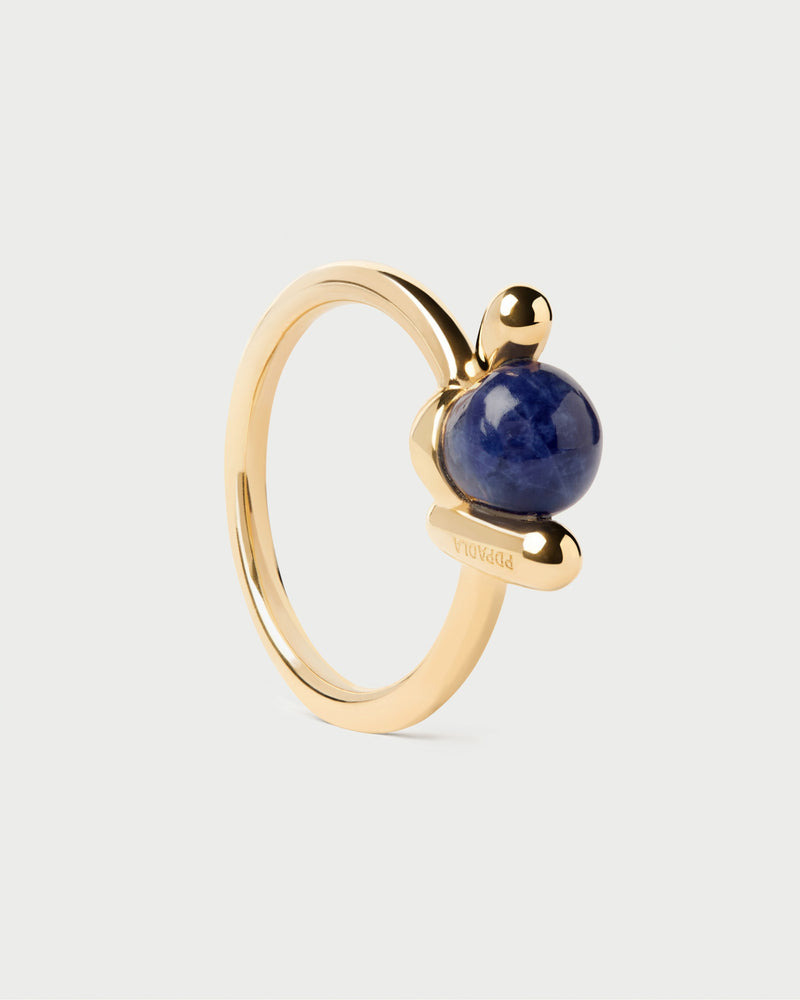 Fluid open knot ring inlaid with a round hand-carved royal blue gemstone