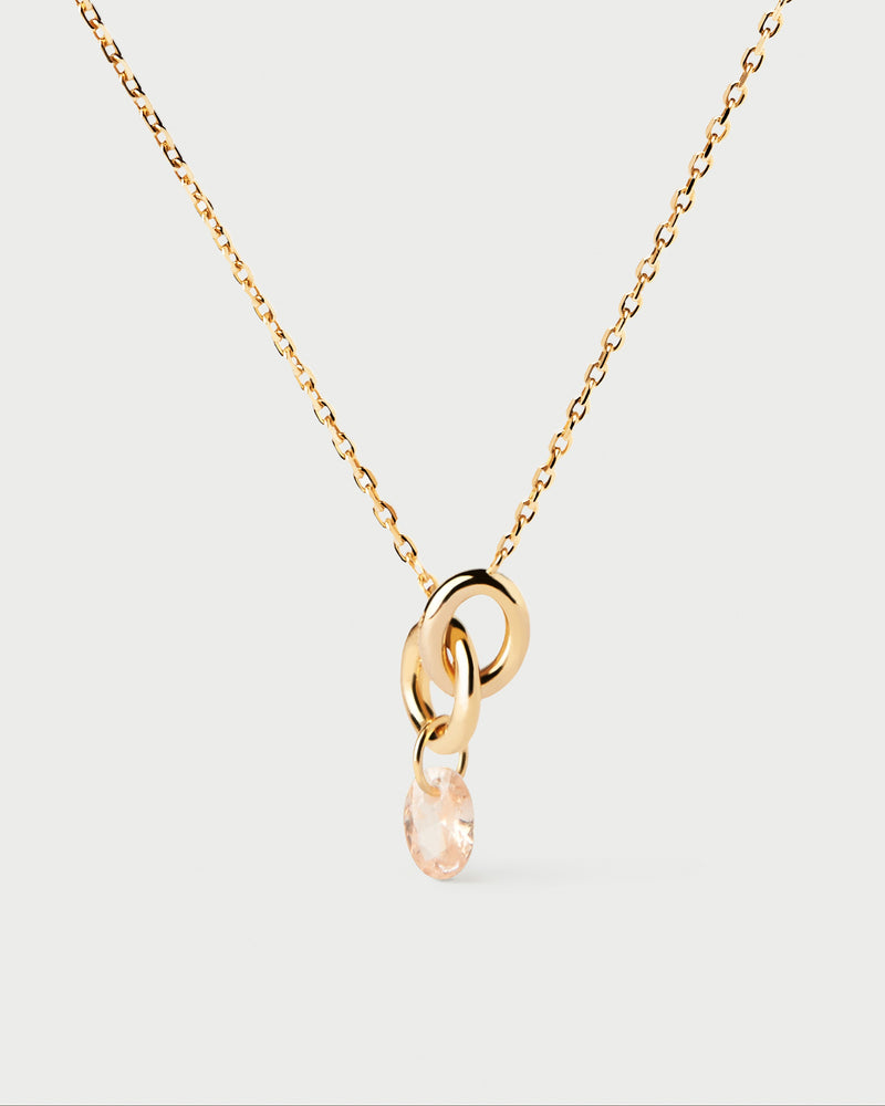 Gold-plated necklace featuring two interlinked rings with a peach zirconia drop pendant