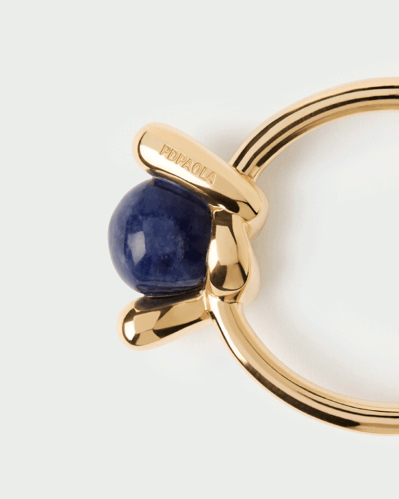 Fluid open knot ring inlaid with a round hand-carved royal blue gemstone